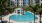 a pool with palm trees and buildings